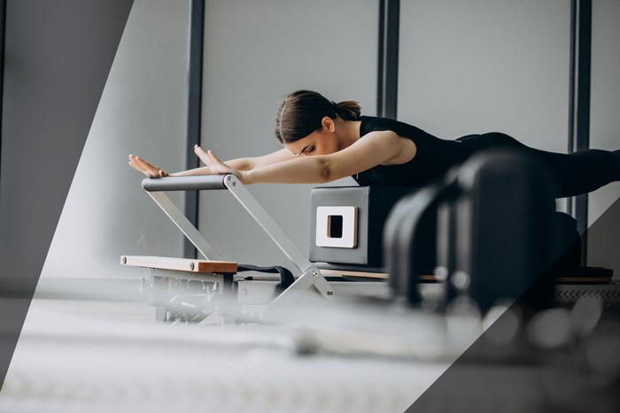 A woman using a reformer pilates machine